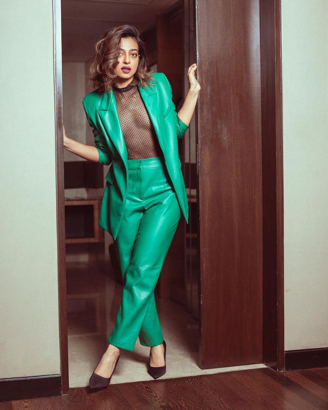 Radhika Apte`s fashion statement features a green tailored trousers and blazer combination, paired with a mesh top underneath.